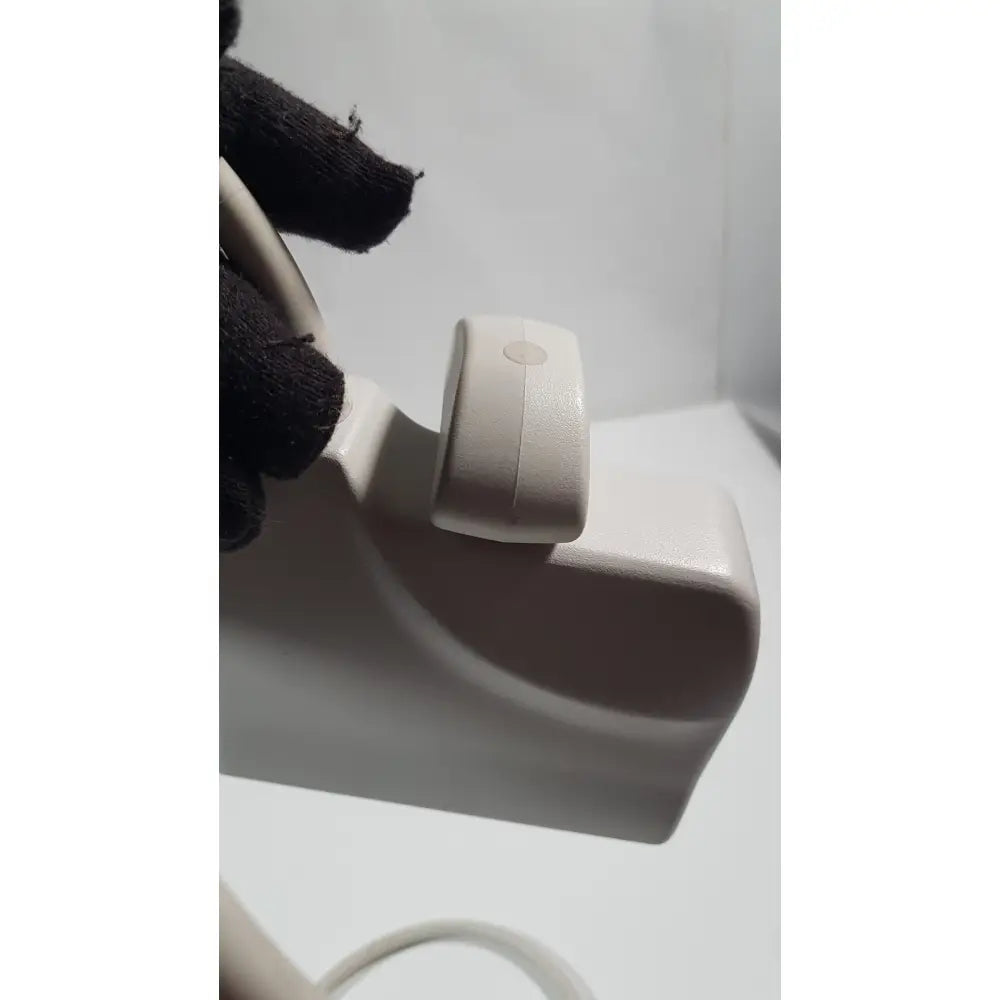 A sleek off-white plastic philips l15-7io linear array ultrasound transducer probe with a small circular button