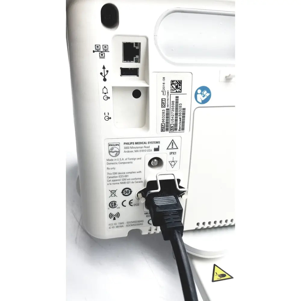 Rear panel of white philips suresigns vs4 vital signs monitor with black power cord plugged in for medical use