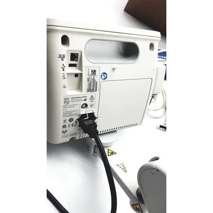 White philips suresigns vs4 vital signs monitor with black power cord plugged in showing back side connections