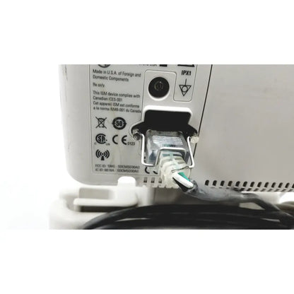 White plastic ethernet port with connected network cable and labels on back of philips suresigns vs4 vital signs monitor