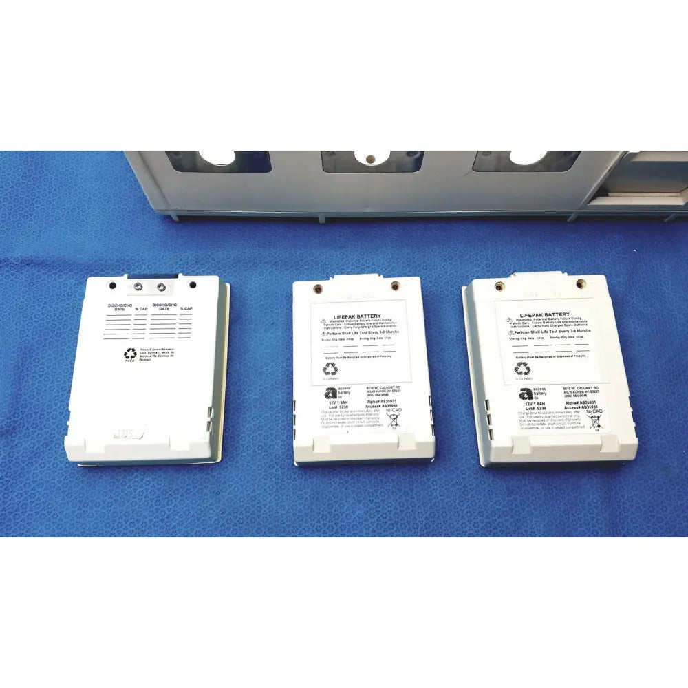 Three white physio control lifepak battery packs with printed specifications and recycling symbols for lifepak 10 monitor