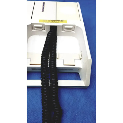 Black coiled cable extending from a white physio control lifepak 10 cardiac monitor showing the back side connection
