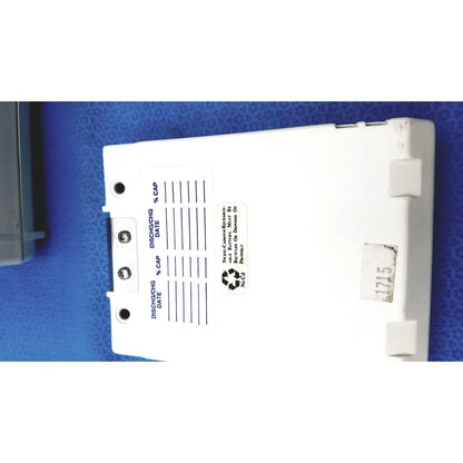 White plastic battery pack with discharge and capacity labels on back side of physio control lifepak 10 cardiac monitor