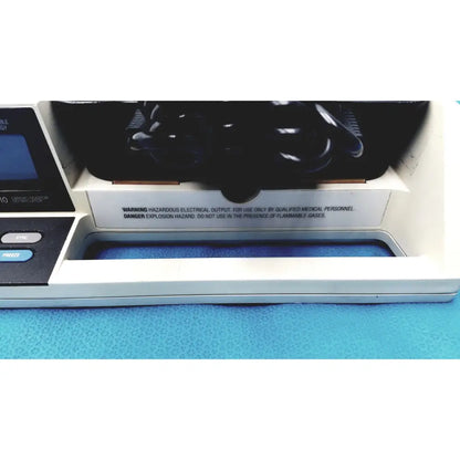 White physio control lifepak 10 cardiac monitor with black control panel blue tray and hazardous electrical output warning label