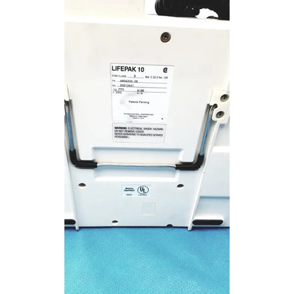 Physio control lifepak 10 cardiac monitor with white case black handle grips and label showing model and safety warnings