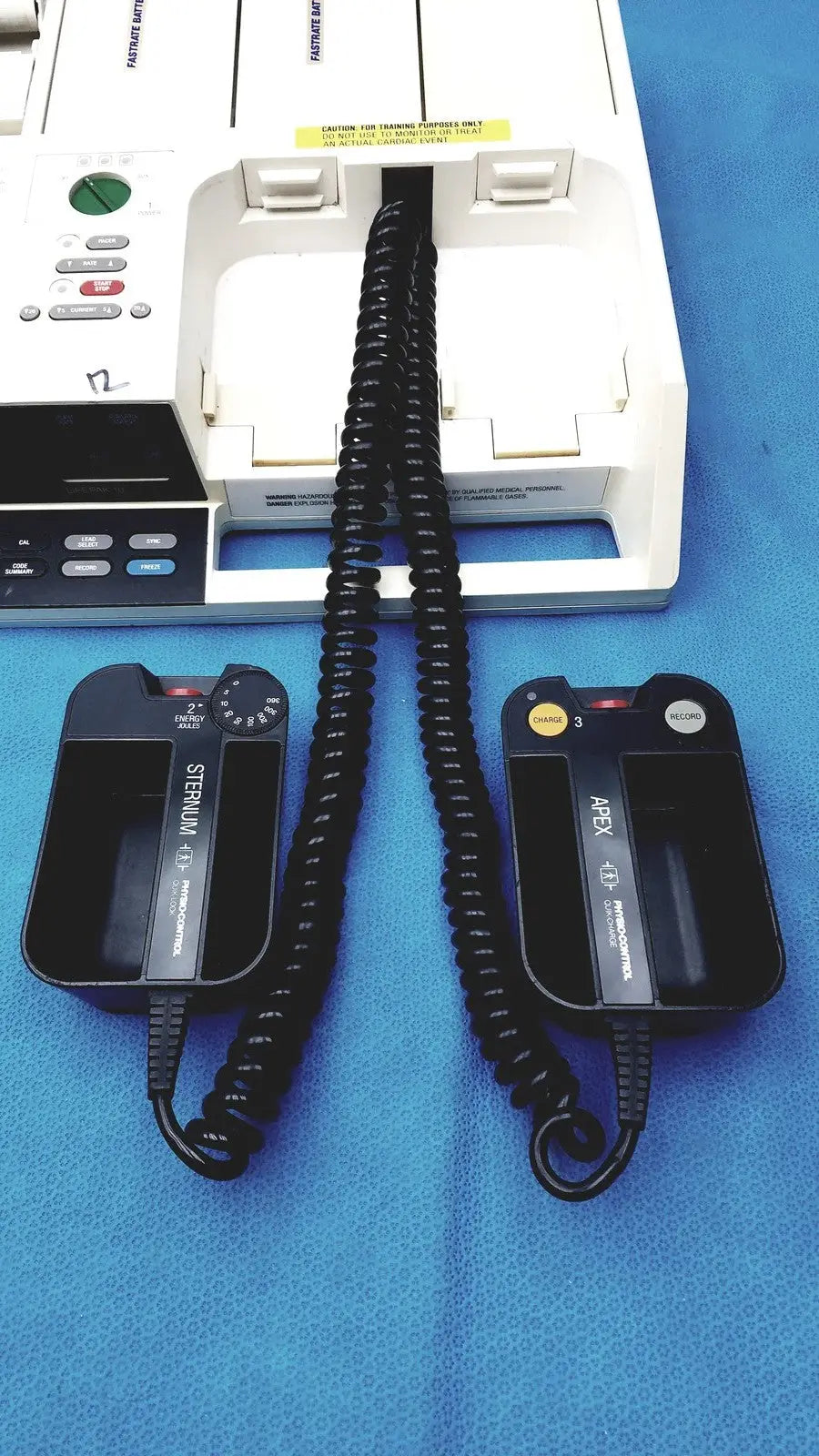Black coiled cable connecting black sternum and abex 1d defibrillator pads on physio control lifepak 10 cardiac monitor