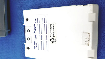 White plastic battery pack with discharge and capacity labels on back side of physio control lifepak 10 cardiac monitor