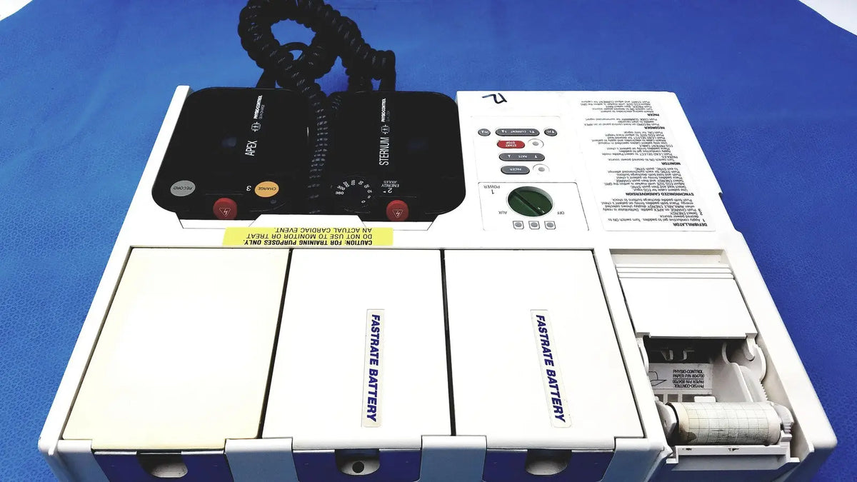 White physio control lifepak 10 cardiac monitor with black control panel and two labeled battery compartments visible