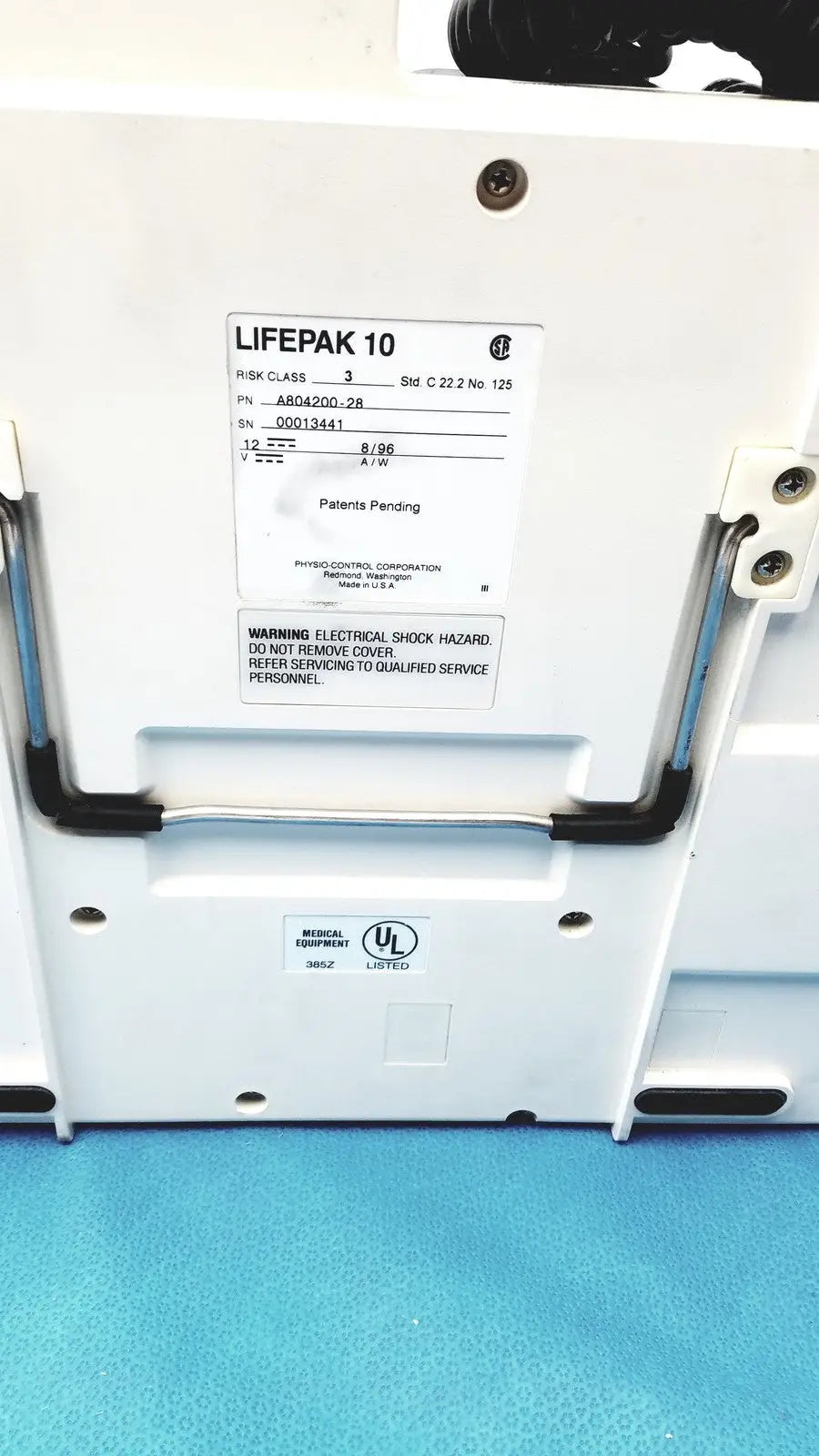 Physio control lifepak 10 cardiac monitor with white case black handle grips and label showing model and safety warnings