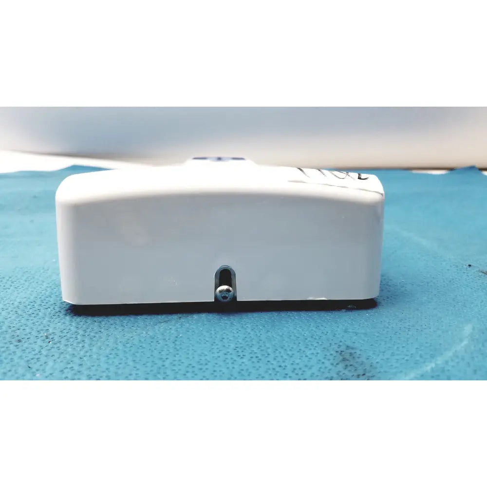 White rectangular plastic planmeca intra x-ray control pad with small silver screw and black base visible from back side