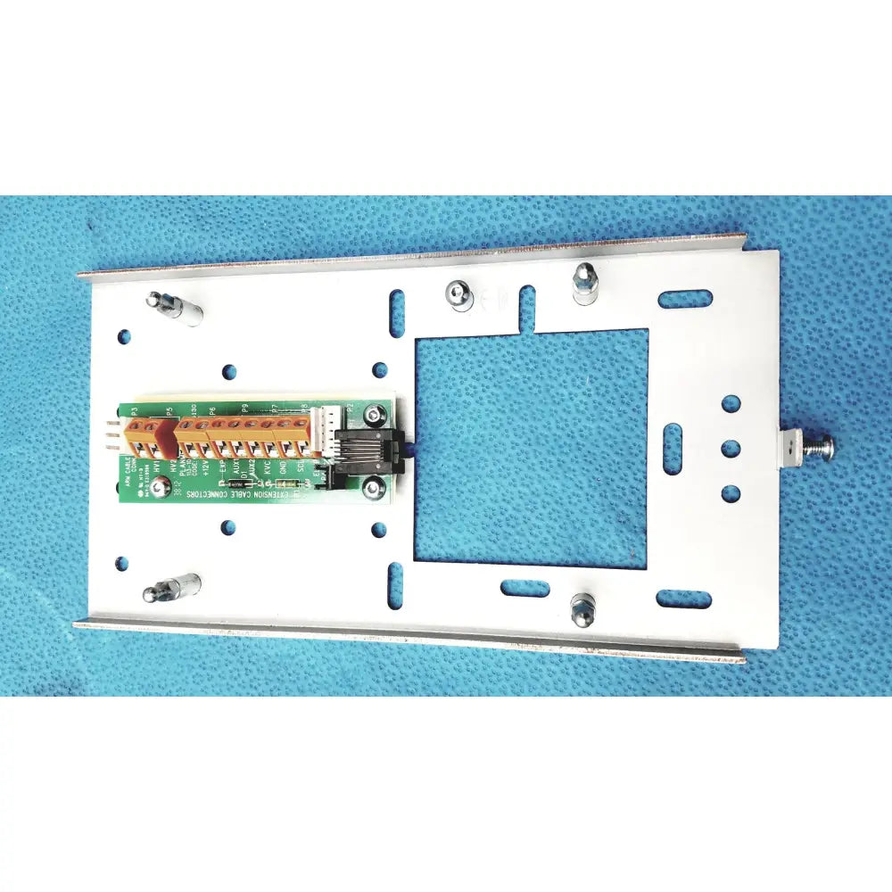 White metal mounting plate with green circuit board and orange terminal block on planmeca intra x-ray control pad back side