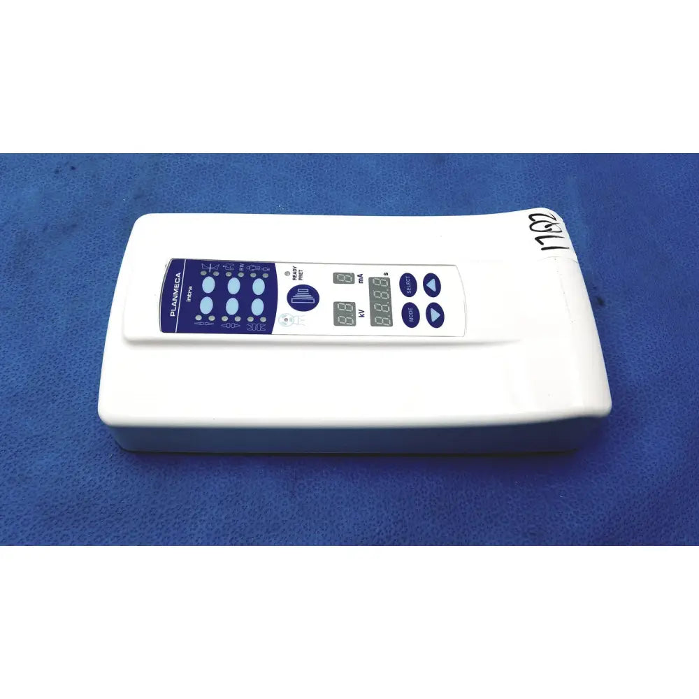 White rectangular planmeca intra x-ray control pad with blue digital display showing voltage and current settings