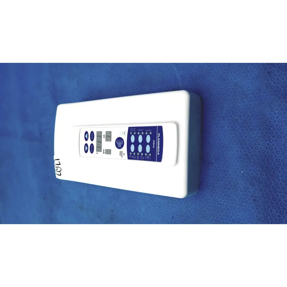 White rectangular planmeca intra x-ray control pad with blue digital display panel branded planmeca on front