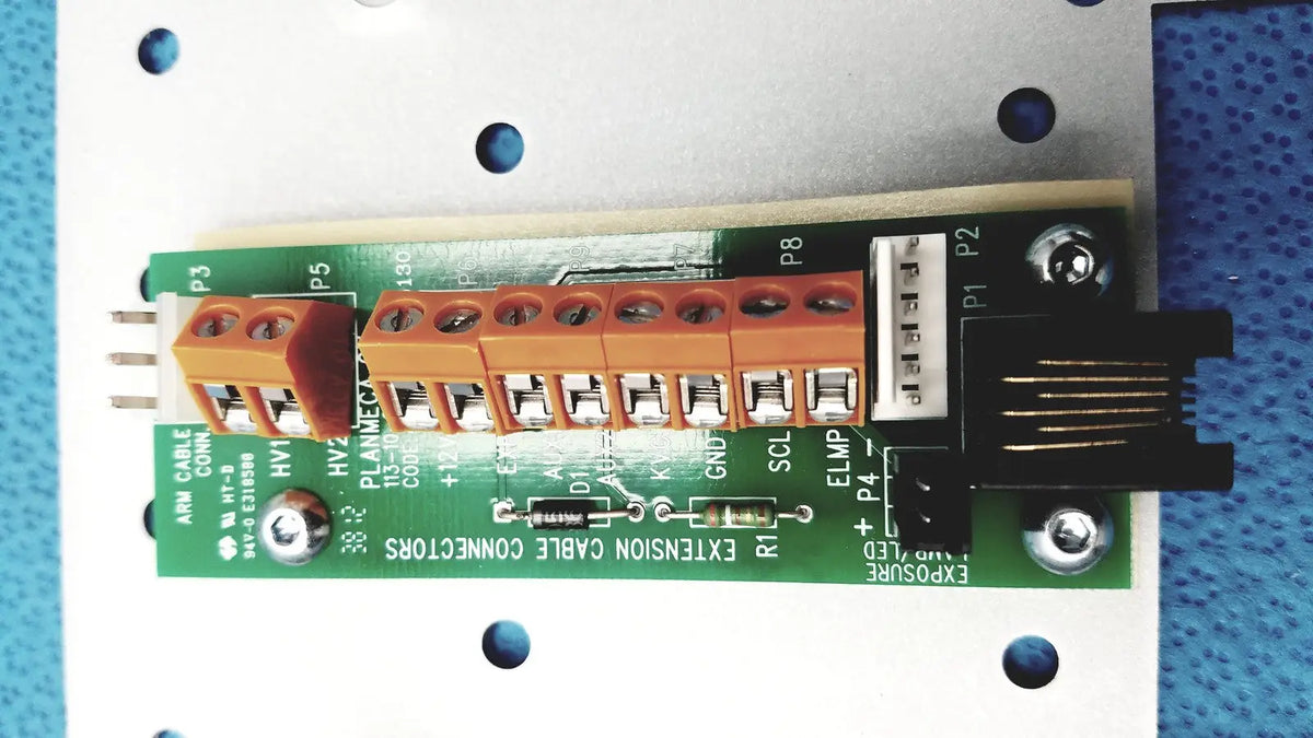Green circuit board with orange terminal blocks and black connectors on the back side of planmeca intra x-ray control pad