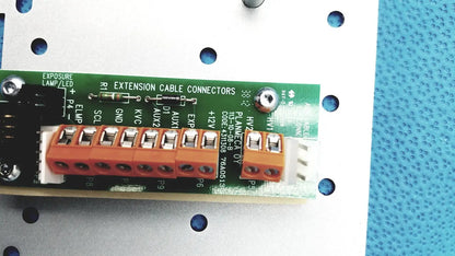 Orange plastic extension cable connectors mounted on a green circuit board of the Planmeca Intra x-ray control pad back side