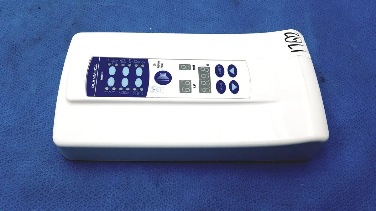 White rectangular planmeca intra x-ray control pad with blue digital display showing voltage and current settings