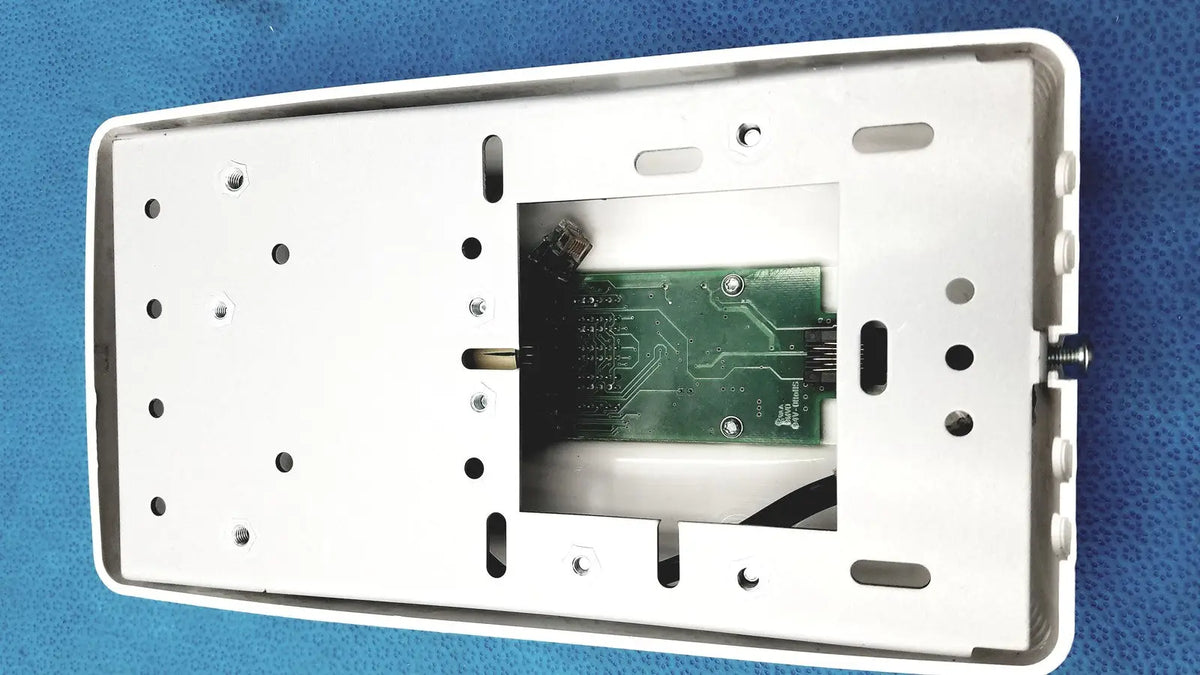White plastic wall-mounted housing with visible green circuit board for planmeca intra x-ray control pad backside view