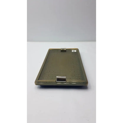 Olive-green plastic sterilization tray with silicone finger mat textured surface and secure metal clasp for surgical use
