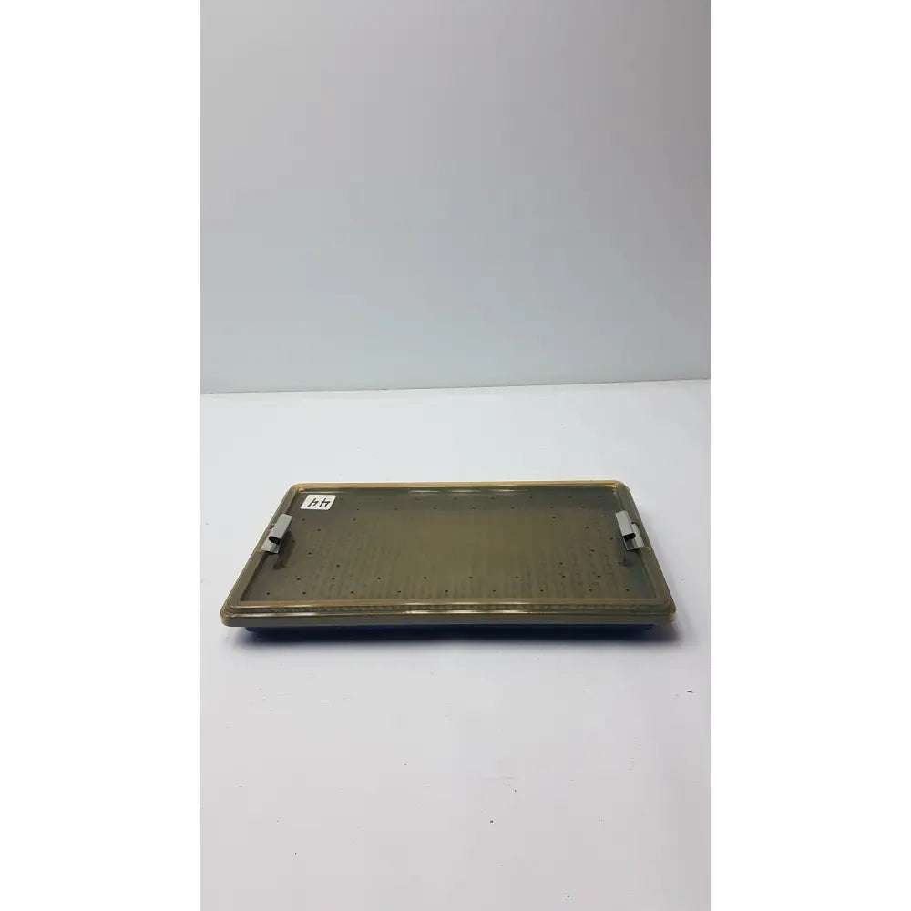 Olive green plastic sterilization tray with two metallic handles and a silicone finger mat for secure instrument storage