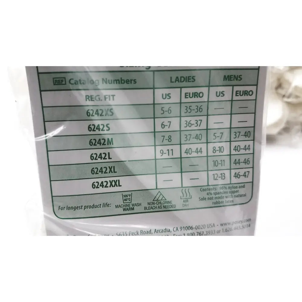 The label on posey quick dry white slippers shows sizing, fabric content nylon spandex, care, and manufacturer details