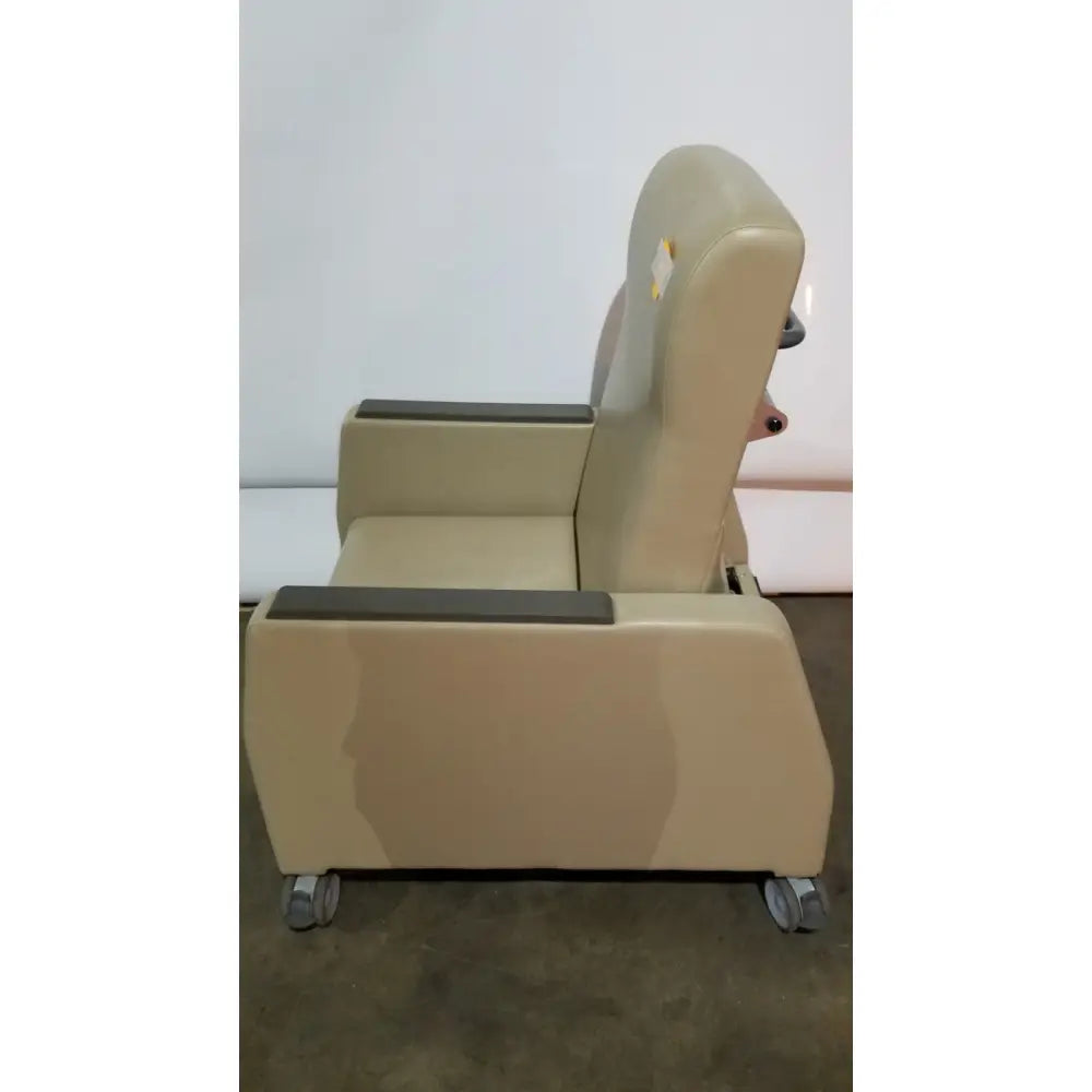 Beige upholstered power recovery recliner with dark gray armrests and casters featuring hand control for comfort