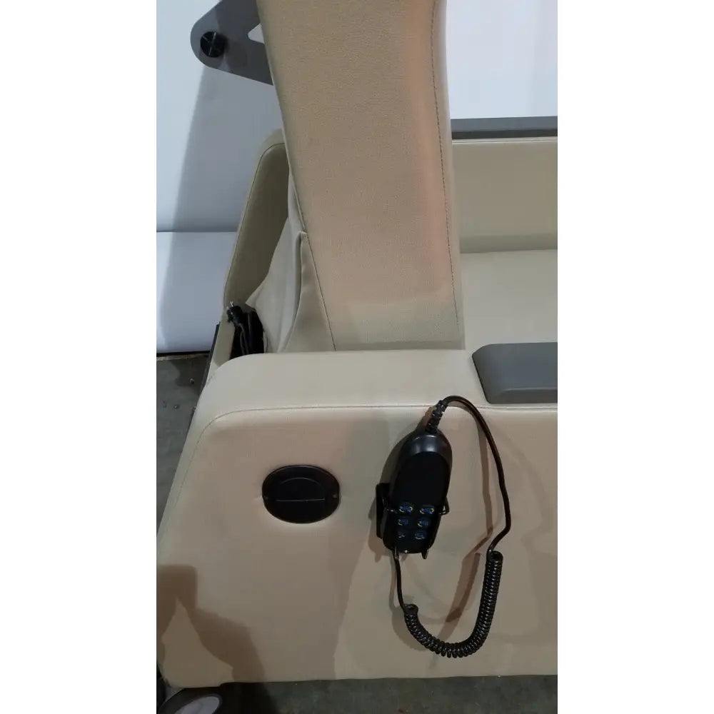 Black handheld vhf marine radio with coiled cord mounted on beige boat seat next to power recovery recliner with hand control
