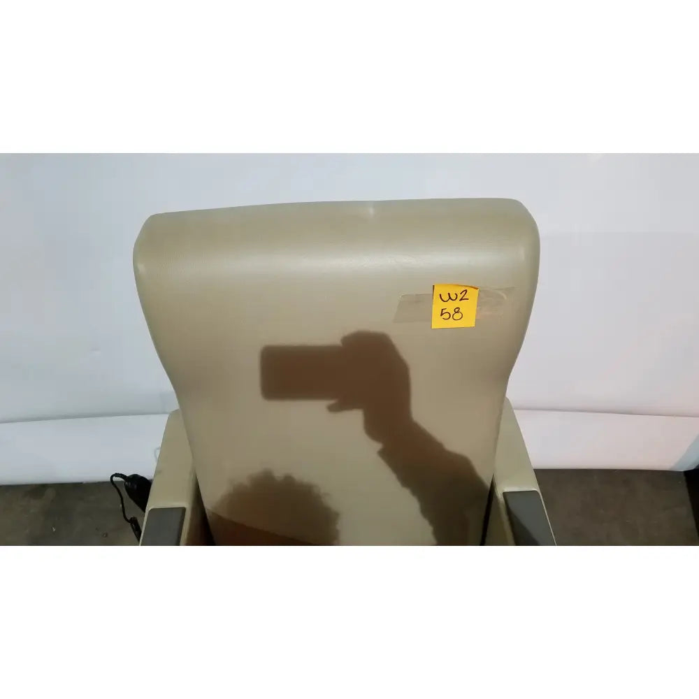 Beige upholstered power recovery recliner with hand control and yellow sticky note on the headrest