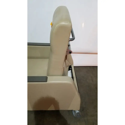 Beige upholstered power recovery recliner with padded backrest armrests and gray metal frame featuring hand control