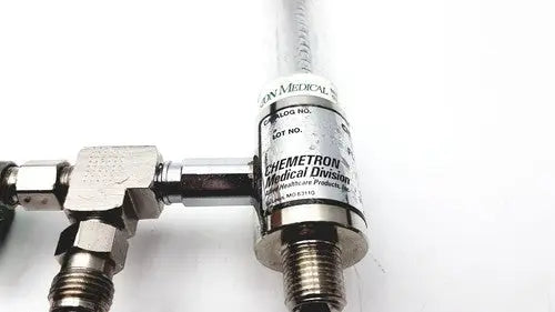 Silver metallic precision medical regulator gauge with clear cylindrical body and chemetron medical division label