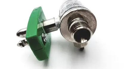 Green plastic precision medical regulator gauge connector with metallic threaded end and two silver pins