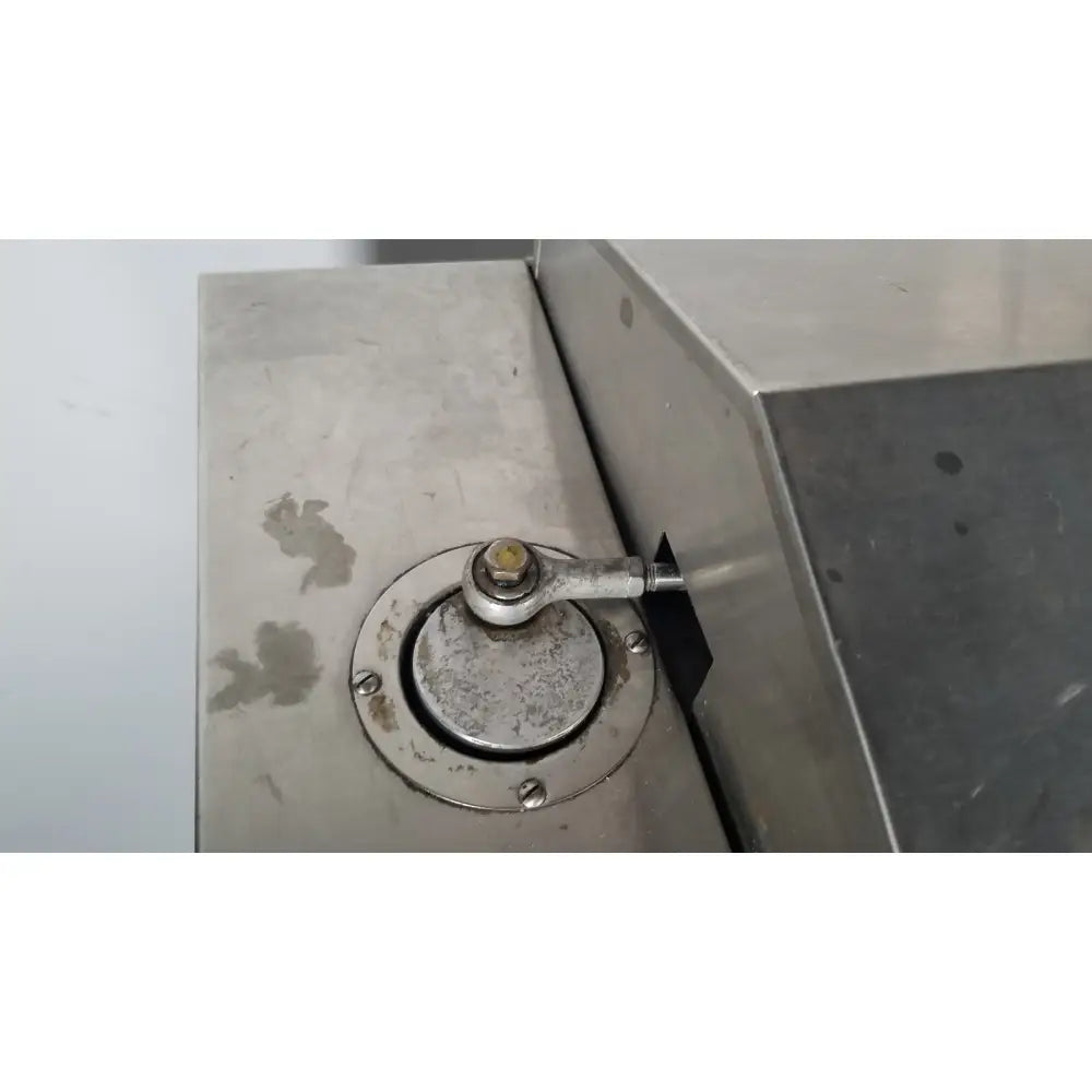 A circular metallic access panel with a bolted handle on the stainless steel surface of a precision scientific metabolic shaking incubator