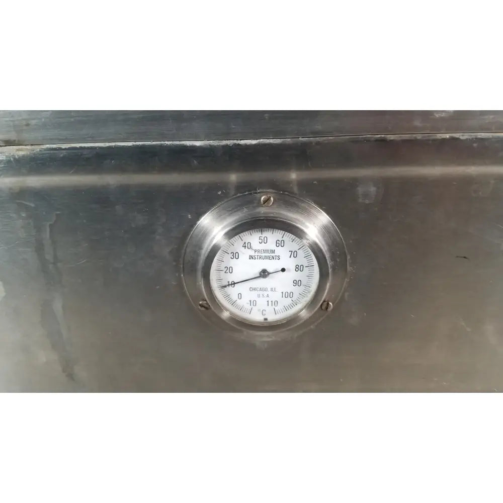 A circular stainless steel thermometer with a white face and black markings on a precision scientific metabolic shaking incubator 66722