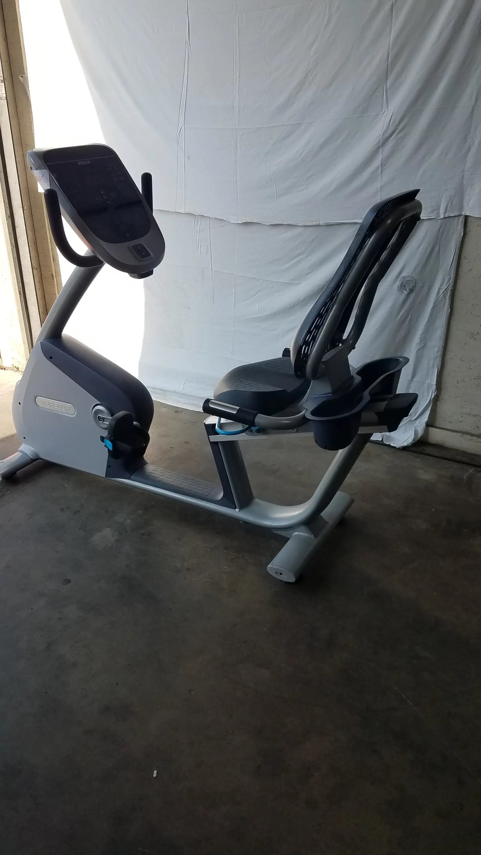 Gray and black recumbent exercise bike featuring precor console with digital display for indoor fitness workouts