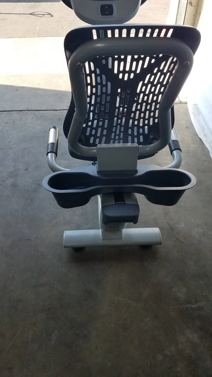 Gray and black precor recumbent exercise bike with perforated backrest adjustable handlebars and precor console cup holders