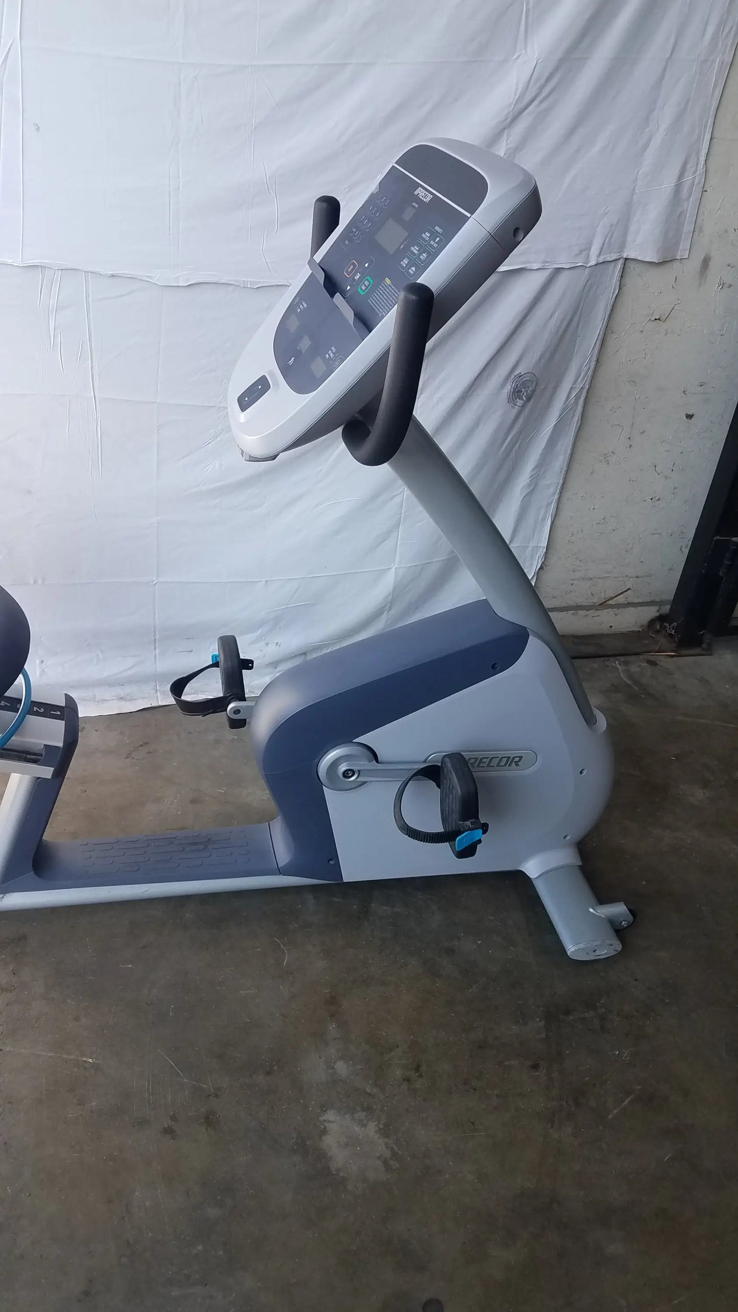 Gray and blue recumbent exercise bike with precor console digital display for comfortable recumbent exercise sessions