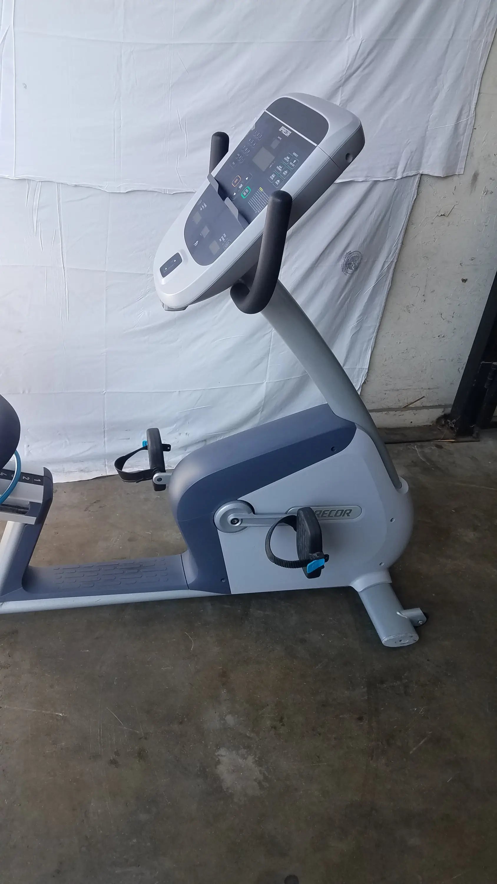 Gray and blue recumbent exercise bike with precor console digital display for comfortable recumbent exercise sessions