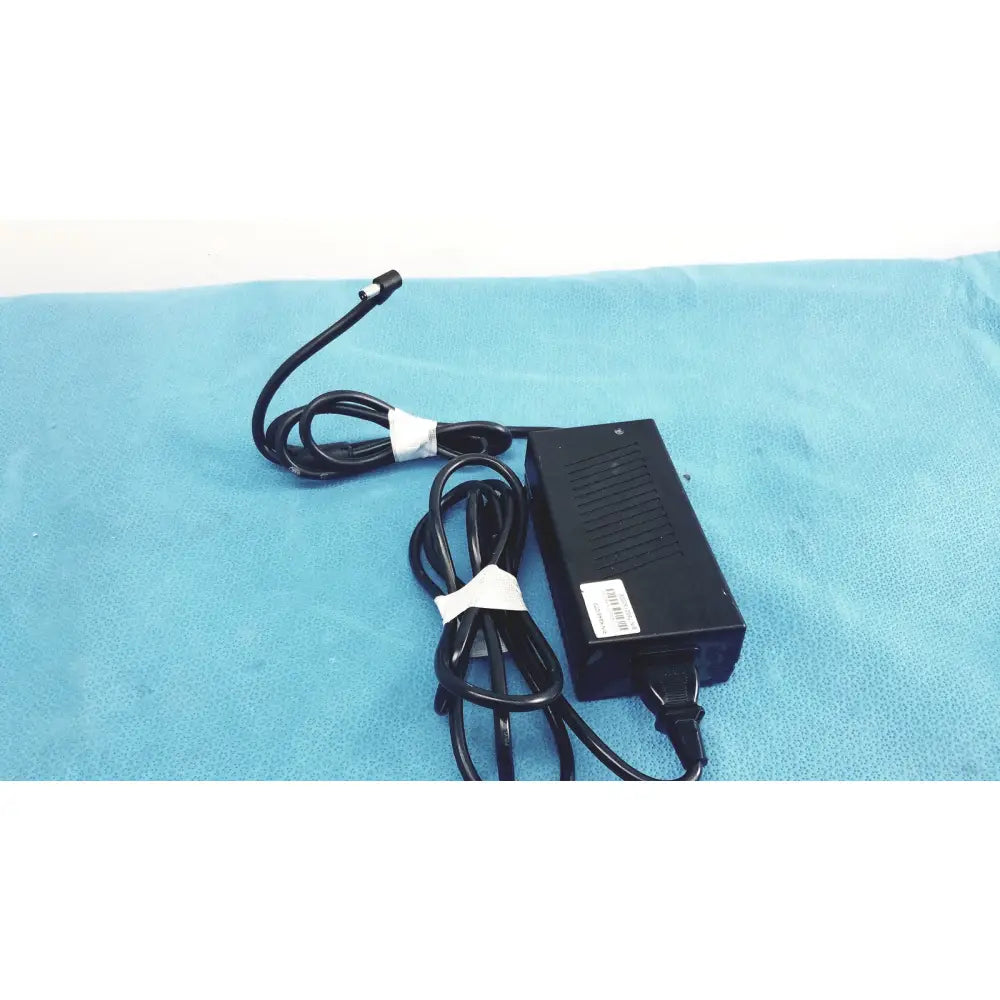 Black plastic protek power model pmp60-12-b16 ac adaptor with coiled black cable and white ties for power supply