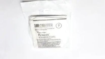 A package of sterile white Protexis surgical glove 2d72pt70x size 7 with barcode and product information visible