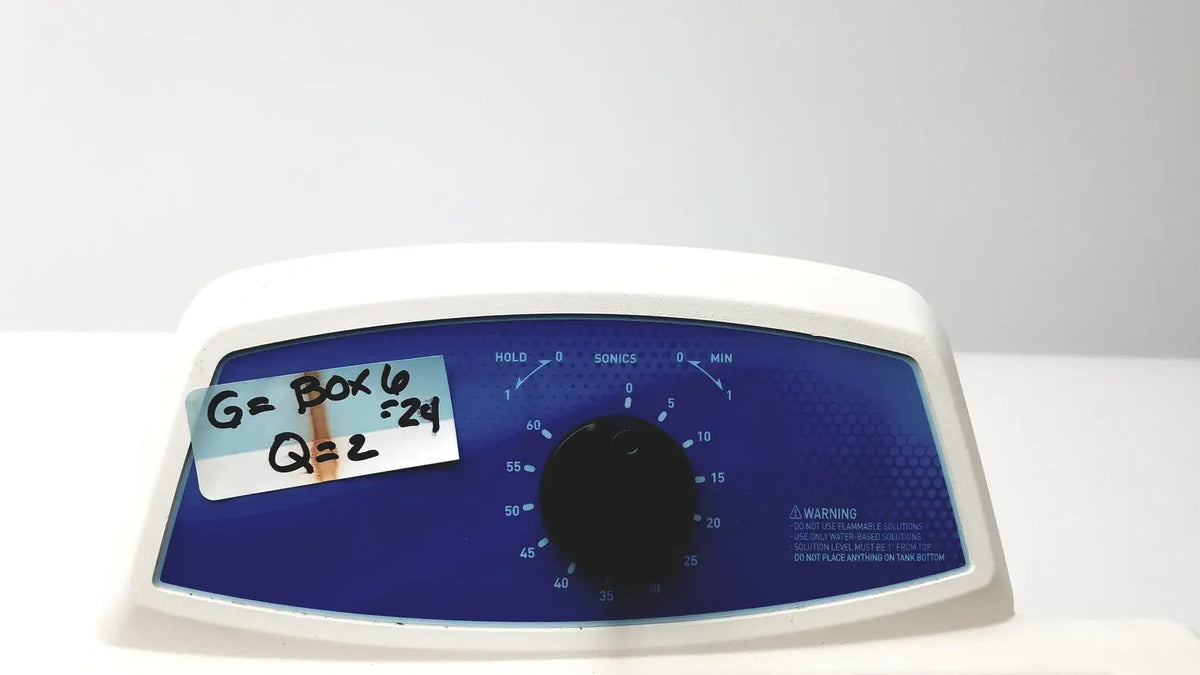 White plastic qsonica c75t ultrasonic cleaner with blue control panel and black rotary dial for timed settings