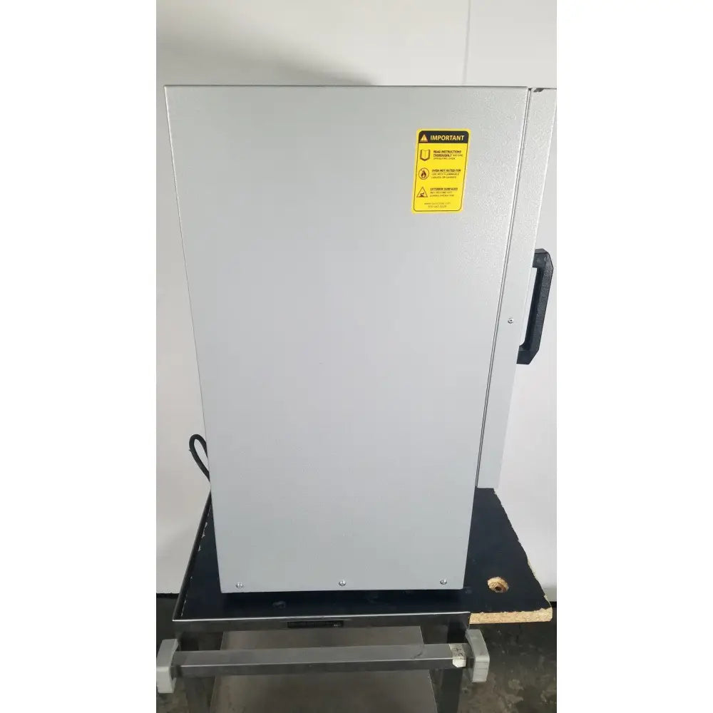 Silver industrial-grade quincy lab 30gc gravity convection lab oven with black handle and yellow warning label on the door