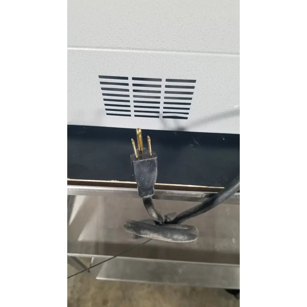 Black electrical plug with three gold prongs connected to a cord at the back of quincy lab 30gc gravity convection oven