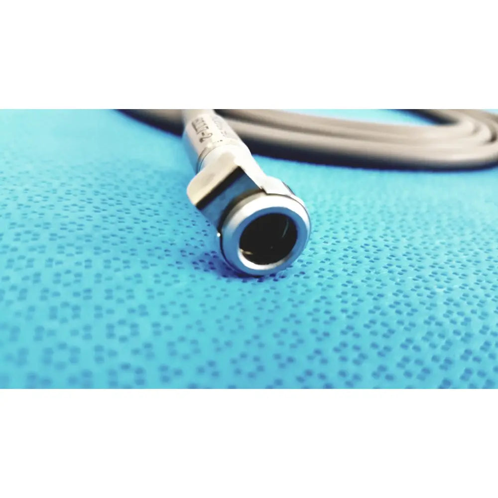 Silver-colored metal fiberoptic light cable connector with cylindrical shape and engraved text for surgical illumination