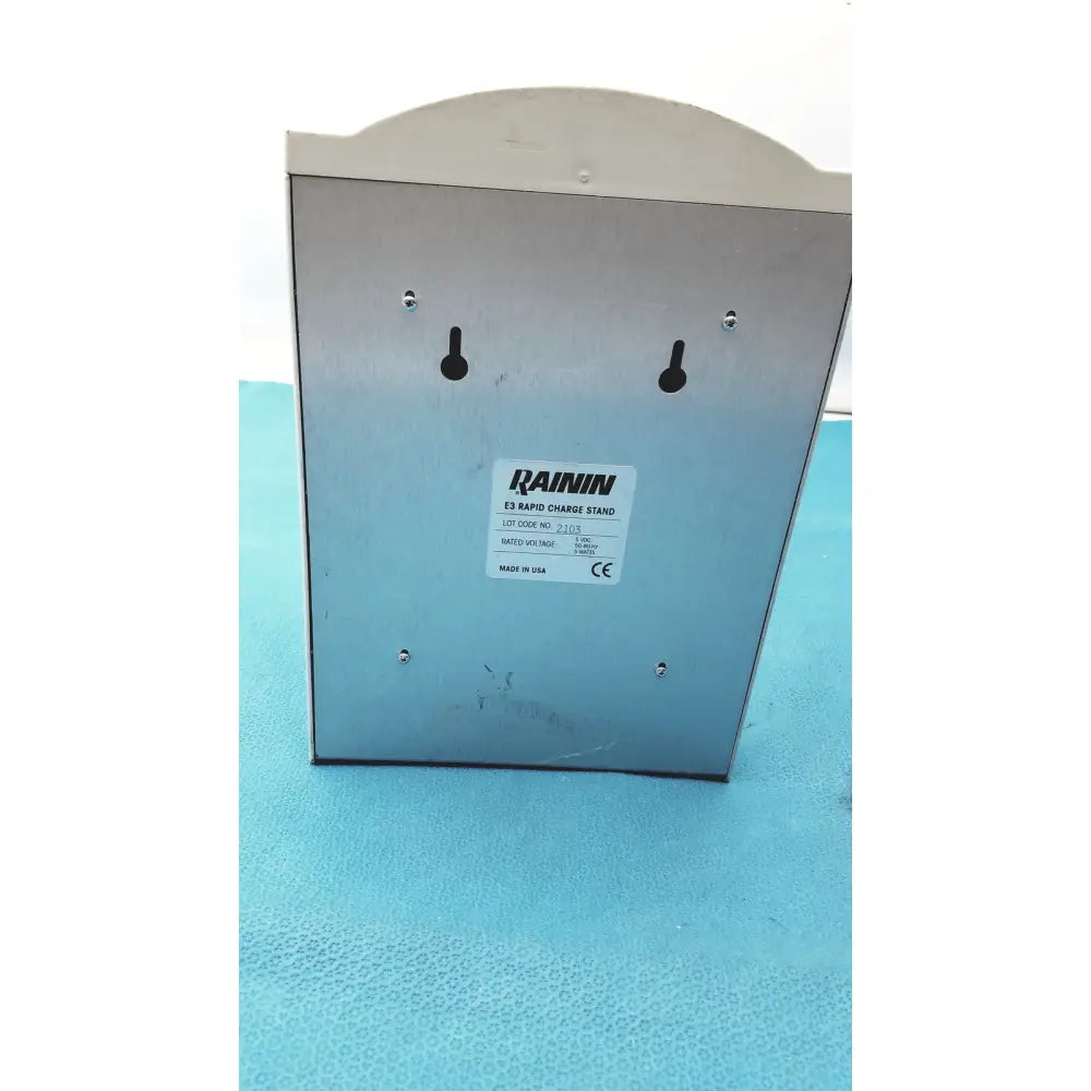 Silver metallic rainin e3 rapid charge stand with four mounting holes and a curved top for efficient rapid charge use