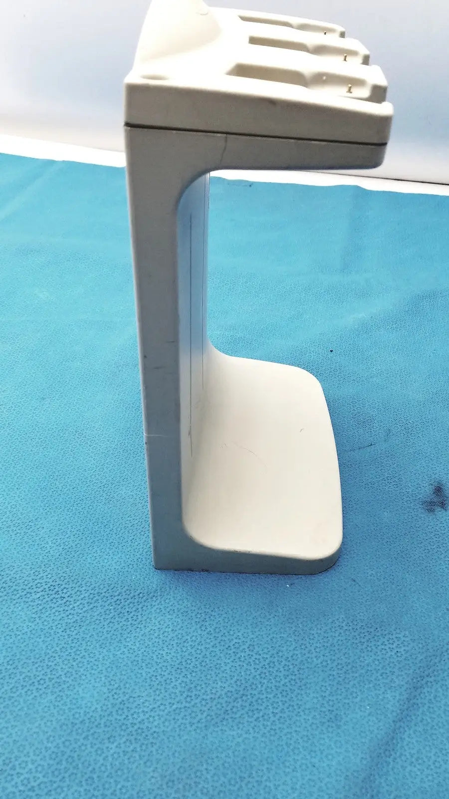 White plastic rainin e3 rapid charge stand with curved base and slotted top for rapid charge use