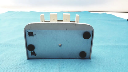 White plastic rapid charge stand with four vertical slots and black rubber feet for rainin e3 rapid charging