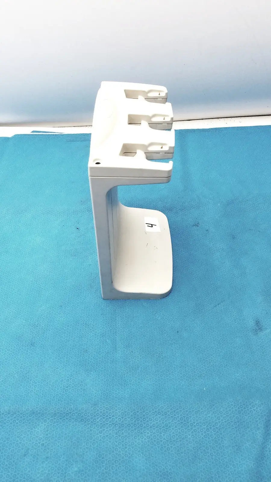 White plastic rainin e3 rapid charger stand with three slots for charging devices in a rapid charger design