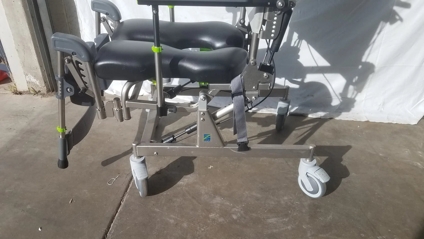 Raz attendant tilt shower commode chair with adjustable recliner, black padded seat, silver frame, and green accents