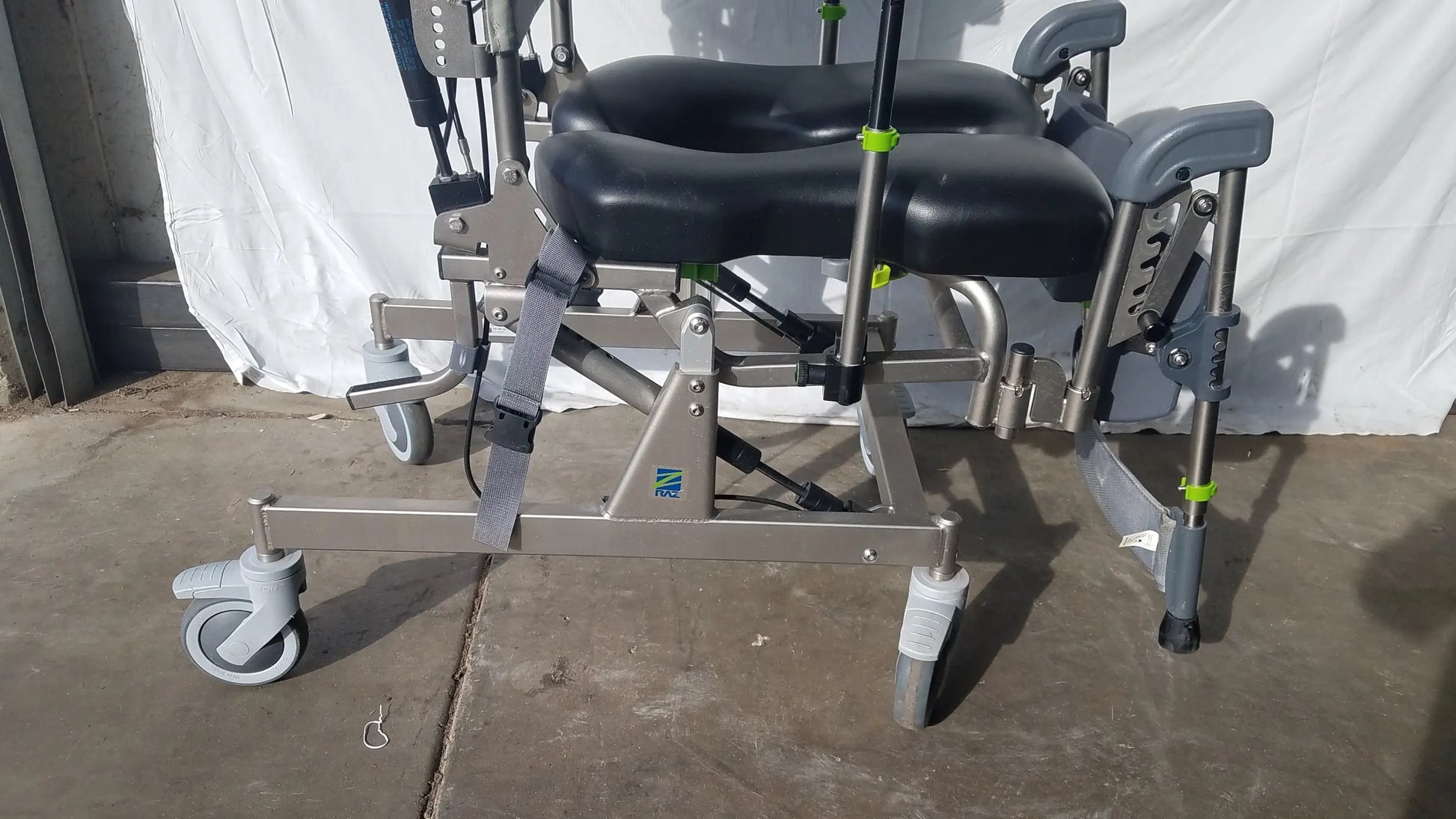 Gray and black adjustable raz attendant tilt shower commode chair with padded seat footrest metal frame and caster wheels