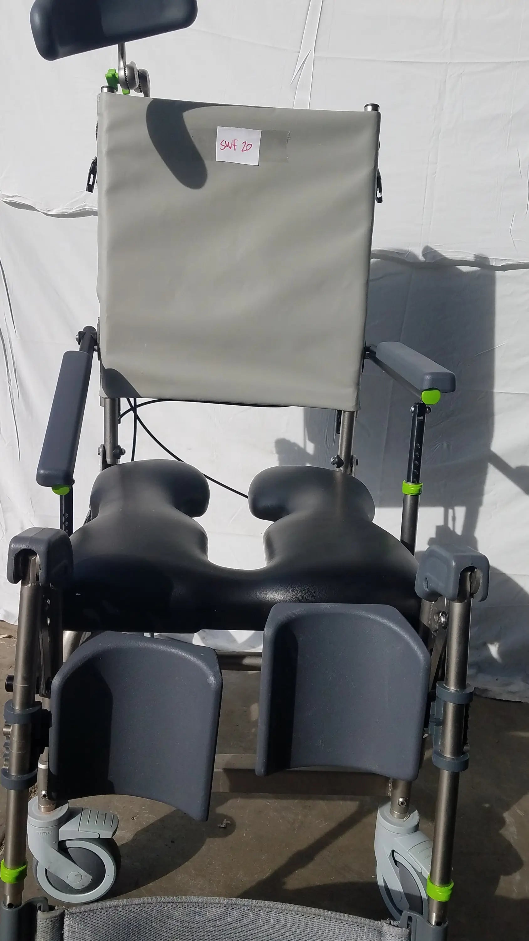 Raz attendant tilt shower commode chair with gray and black adjustable seat and green-accented metal frame commode chair