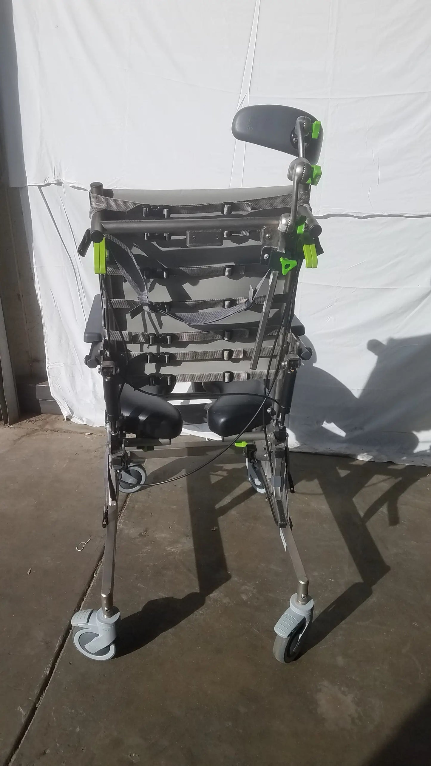 Gray and black raz attendant tilt shower commode chair with adjustable armrests padded seat and four caster wheels
